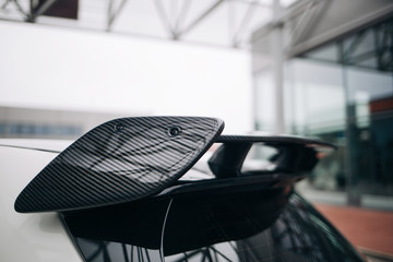 Carbon spoiler on the trunk of modern hatchback car. Fast hatchback with roof wing spoiler 