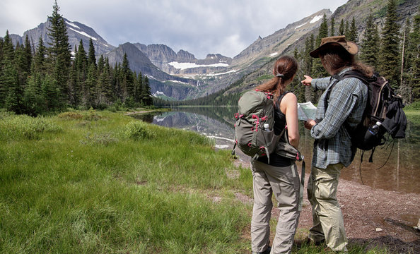 Hiker With Hiking Map In Glacier National Park, Montana, USA 