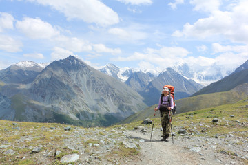 Tourist woman climbing by Pass Kara-Turek against the Belukha Mountain, Altai, Russia