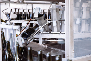 Glass bottles on the automatic conveyor line at the champagne or wine factory. Plant for bottling alcoholic beverages.