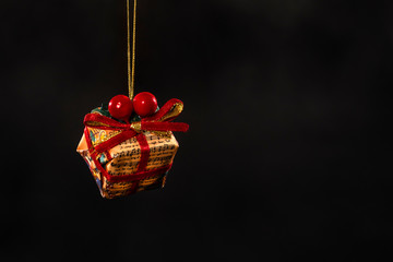 Merry Christmas - festive Christmas decoration with colorful Christmas gift box isolated on black dark background and copyspace for text - concept x-mas decoration ornament winter present greeting