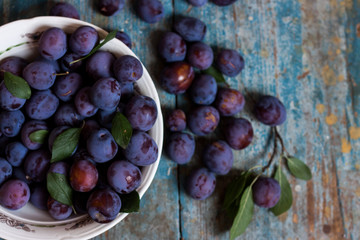 Plum plate on wooden background.