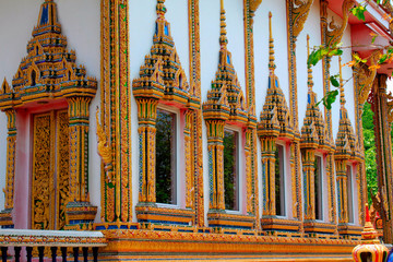 Doors and windows of the temple adorned by intricate wooden carvings in golden color depicting...