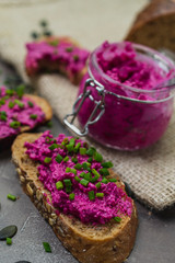 Beetroot spreads on dark, whole-grain bread in village style. healthy dinner or snack concept.