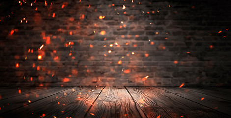 Dark basement room, empty old brick wall, sparks of fire and light on the walls and wooden floor....