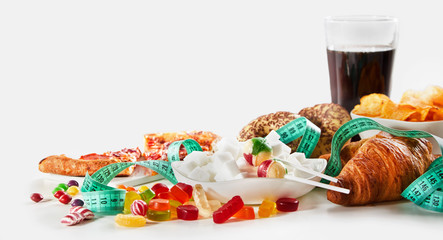 Measuring tape between sweets and junk food