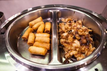 hotel restaurant food catering service buffet banquet for wedding ceremonies, seminar, meeting, conference, parties or event. spring rolls and pepper chili herb fried chicken in Warm chafing dish