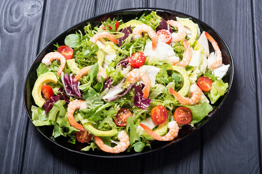Mix of salad with shrimps , avocado and cherry tomatoes