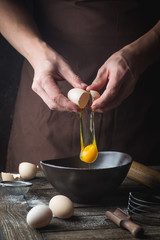 hands are breaking an egg