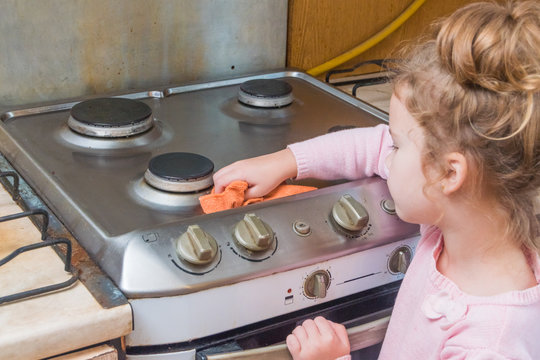 Girl, Child Washes Stove For Cooking, In The Kitchen