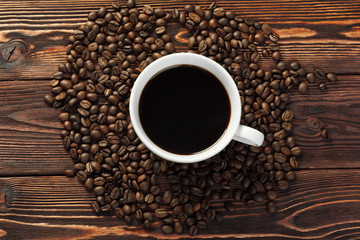 Coffee cup and coffee beans on wooden background
