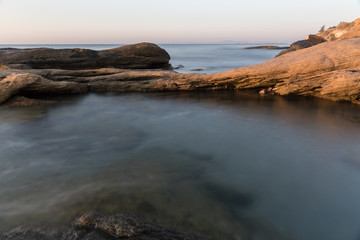 Fototapeta na wymiar The wild sea beach with stones at sunrise. Bulgaria
