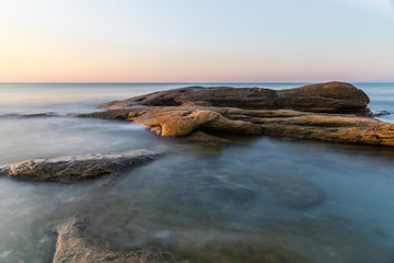 Fototapeta na wymiar The wild sea beach with stones at sunrise. Bulgaria