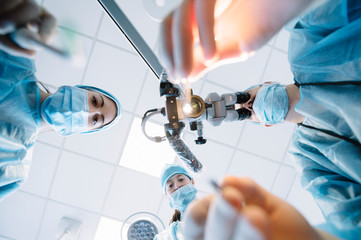 Dentist during a dental intervention with a patient. Dental clinic concept.