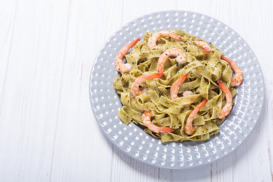 Pasta tagliatelle with sauce pesto and shrimps
