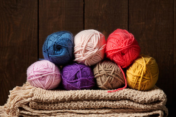 balls of woolen yarn for knitting on wooden background