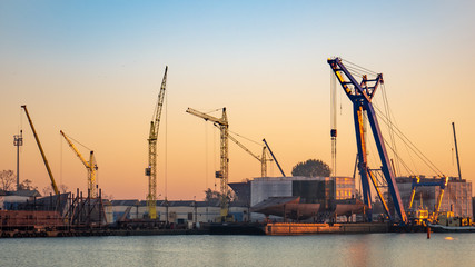 Fototapeta na wymiar Industrial landscape with shipyard and cranes on river.