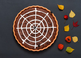 Homemade chocolate brownie cake with spider web for Halloween party. Top view.