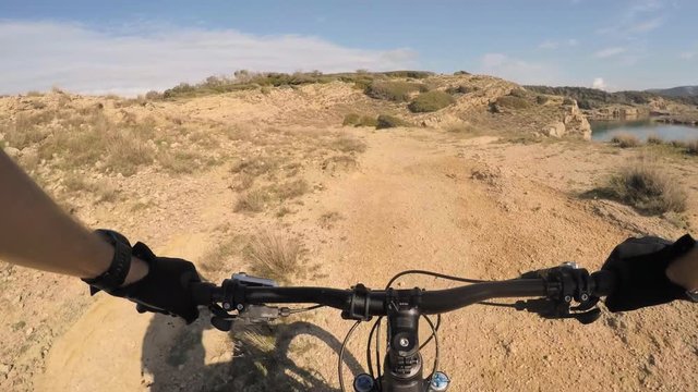 Man riding enduro mountain bike on rocky trail at the seaside in Croatia. View from first person perspective POV. Gimbal stabilized video. Shot with GOPRO HERO4 2.7K.