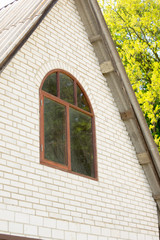 Fototapeta premium facade of the house of brick brown attic with a window against the sky