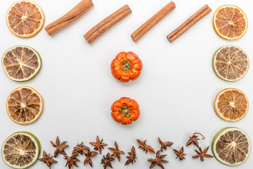 autumn composition with slices of dried oranges, pumpkins, anise flower and cinnamon on a white background, autumn concept, flat lay, top view