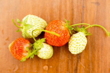 White and red strawberries lie in the sun. Delicious and sweet dessert berry. Vitamins