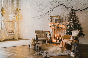 Christmas at home, cozy armchairs near the fireplace. Pine tree with colorful balls, toys and garlands. Winter ornaments. New Year decorations and gifts. Coziness, celebration, winter, feast, holidays