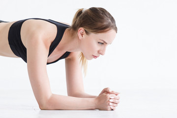 Fototapeta premium Beautiful girl athlete does exercise - plank