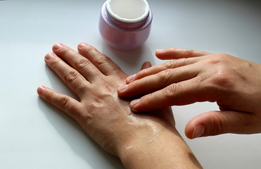 women's hands smear hands with moisturizing cream