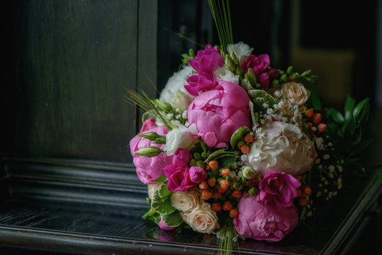 Beautiful wedding bouquet with large peonies, berries and greenery, floral arrangement and accessory for the bride's morning preparation, ideas for florists and wedding themes