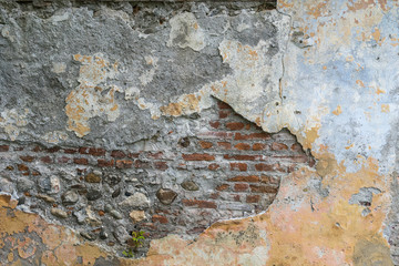 Old wall of brick with a sprinkle plaster.