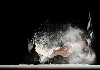 Flour flying into air as man wipes off his hands