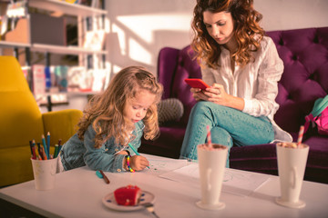 Online chat. Enigmatical child leaning on table while drawing picture