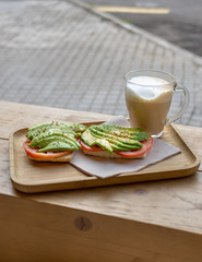Healthy Breakfast Display on a tray with Avocado and tomato on toast with a cappuccino