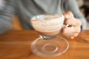 hands holding hot cup of coffee or tea