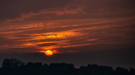 Golden sun touching horizon in sunset