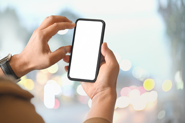 Man using smart phone over blurred bright background