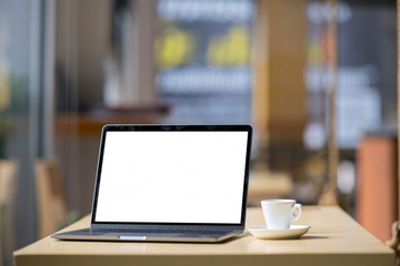 Mockup blank screen laptop on table in cafe background.