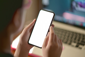 Female hand holding blank screen mobile phone.