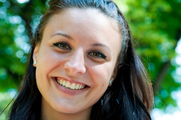 Woman smiling with perfect smile and white teeth in a park