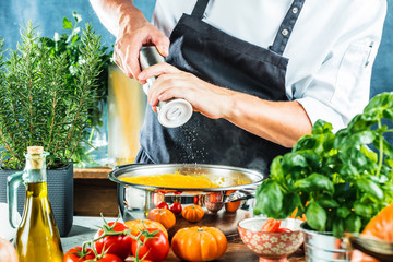 Chef with blender make Pumpkin soup in Kitchen