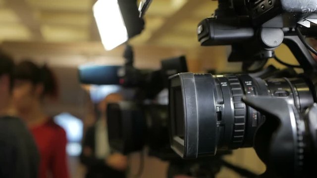 Row of many live TV cameras during important media event.