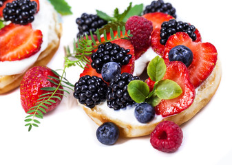 Morning breakfast with mini donuts and berries on plate under powdered sugar on dark background. Tasty donuts closeup. Donuts cut with filling