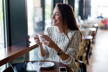 Young beautiful woman drinking coffee in restaurant