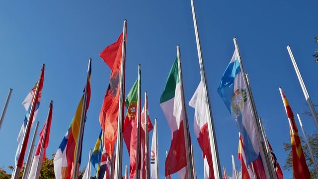 Mehrere Fahnenmasten mit vielen Fahnen im Wind