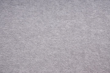 Fototapeta na wymiar gray knitted background, close-up of grey knitwear sweater