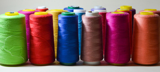 Spools with color threads. Threads of all colors. Isolated. White background.