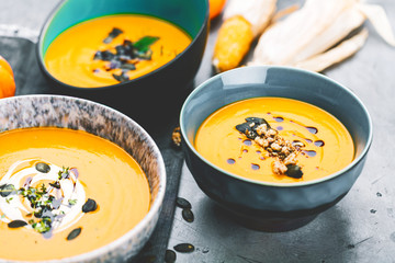 Roasted pumpkin and carrot soup with cream and pumpkin seeds 