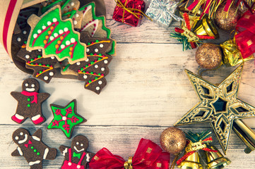 Beautiful Christmas composition and decoration with baked Christmas gingerbread cookie in paper bag on light wooden background, flat lay, top view, copy space (text space)