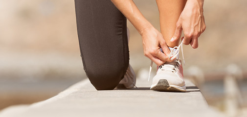 Running shoes being tied by woman getting ready for jogging